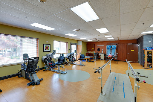 A well-equipped gym designed for rehabilitation and physical therapy, featuring various exercise machines and an inviting atmosphere.