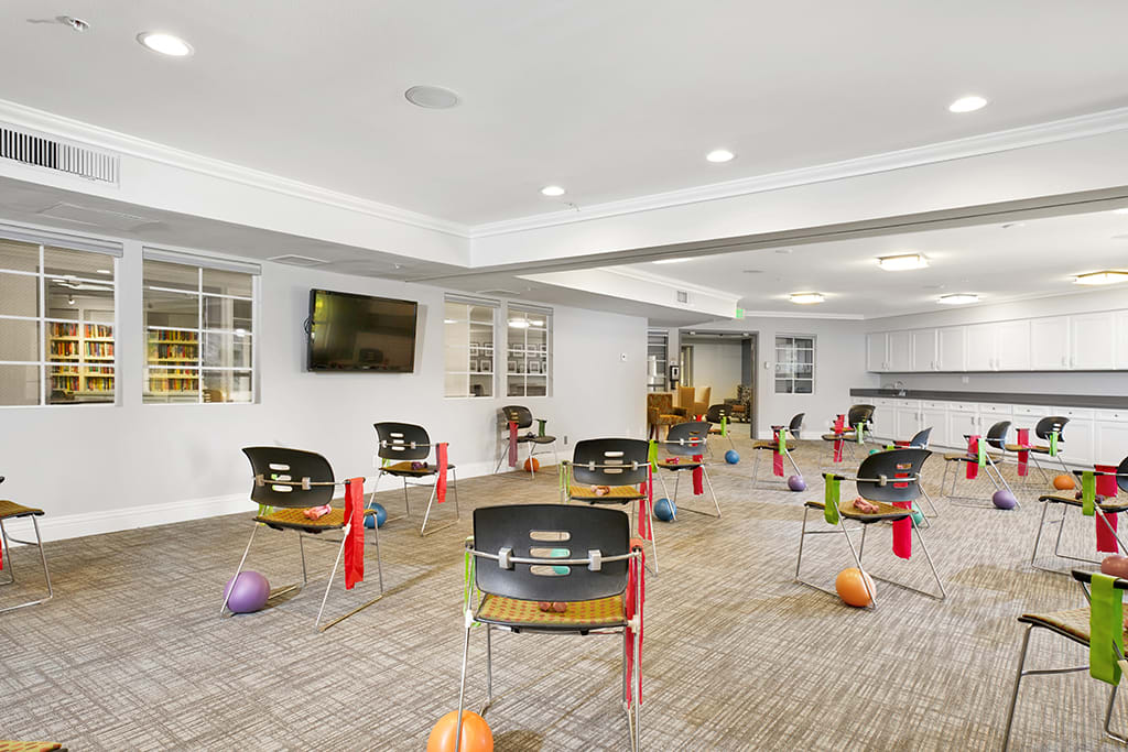 A modern classroom setup with chairs, cones, and various colored balls arranged neatly.