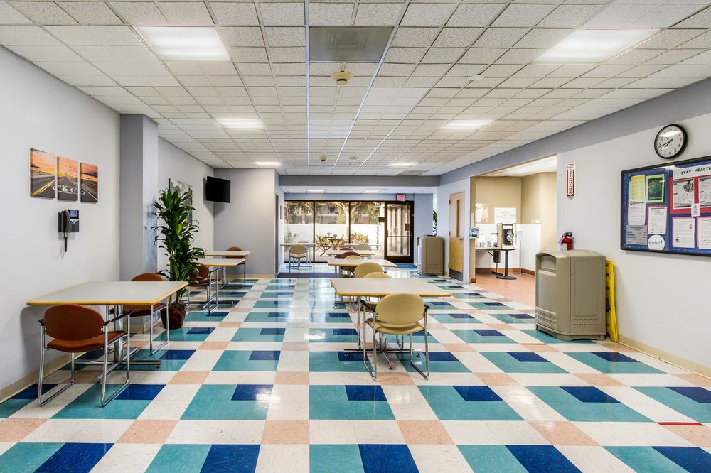 An empty cafeteria with colorful tiled flooring and modern furniture arrangement.