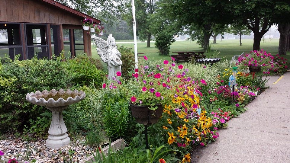 A beautiful garden filled with vibrant flowers and a decorative statue.