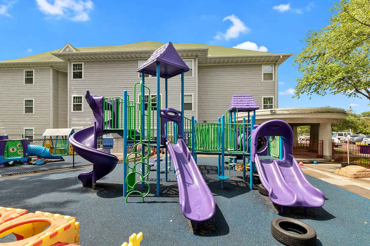 A colorful playground with multiple slides on a sunny day.