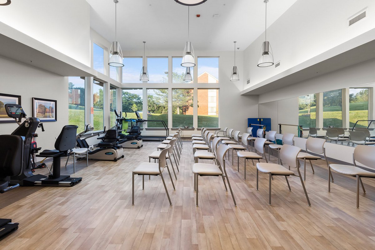 A modern classroom with large windows and neatly arranged chairs and tables.