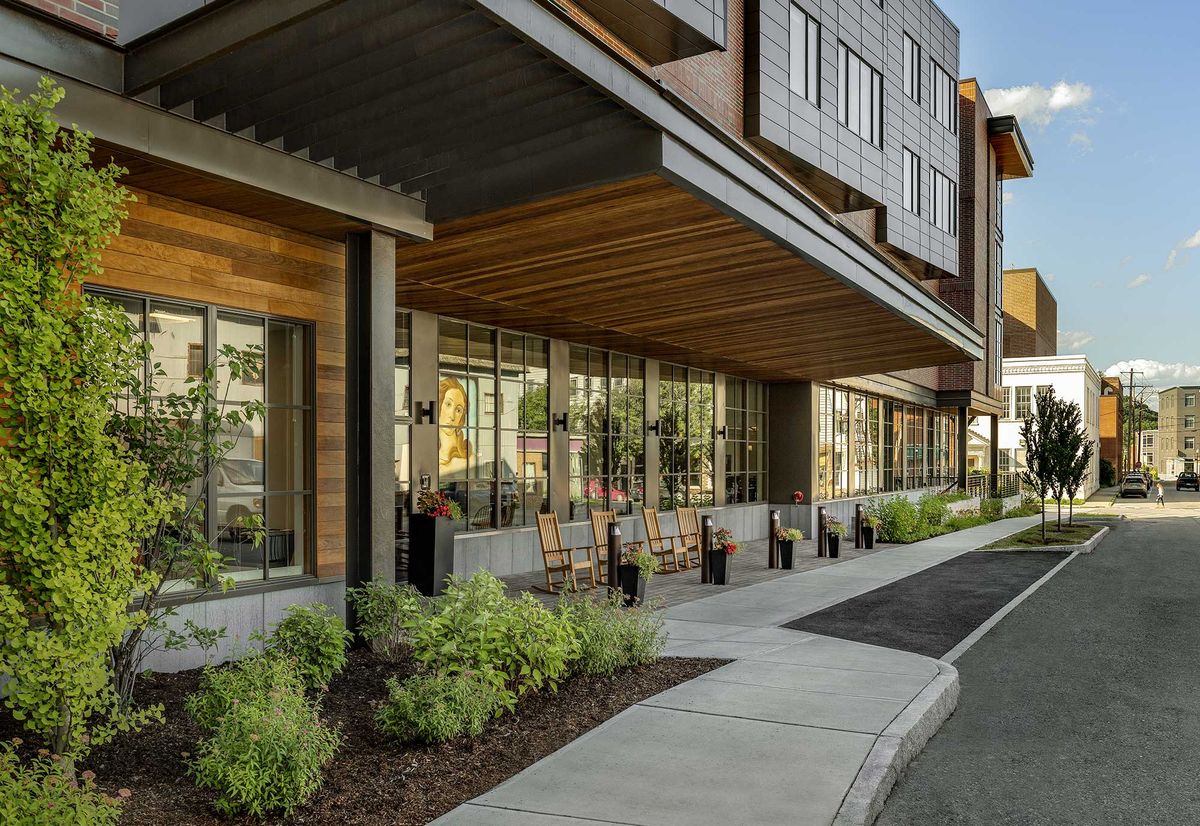 A modern commercial building with large glass windows and landscaped surroundings.
