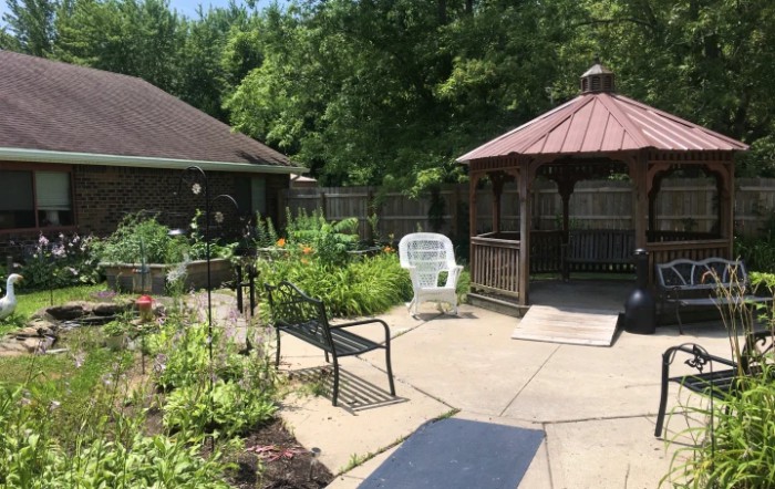 A tranquil garden area with a gazebo and outdoor seating.