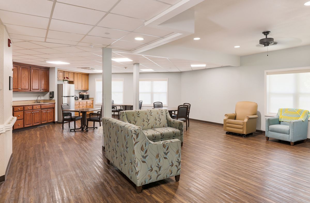 A spacious living area with modern furniture and an adjoining kitchen.