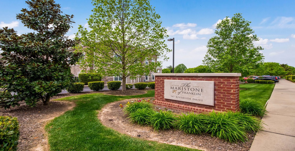 Entrance sign to The Waterstone Apartments with well-maintained landscaping.