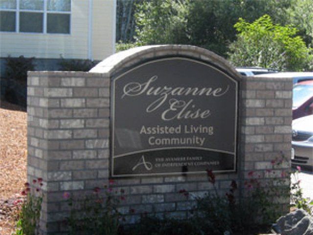Sign for Suzanne Elise Assisted Living Community mounted on a brick wall.