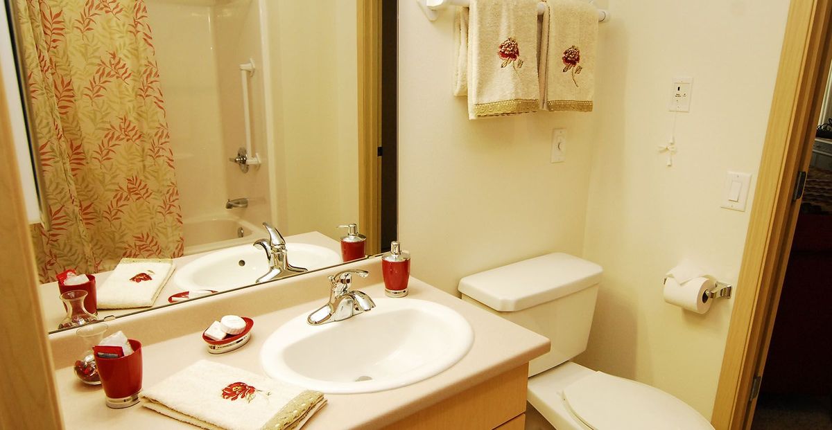 A neatly organized bathroom with a sink, mirror, and towels.