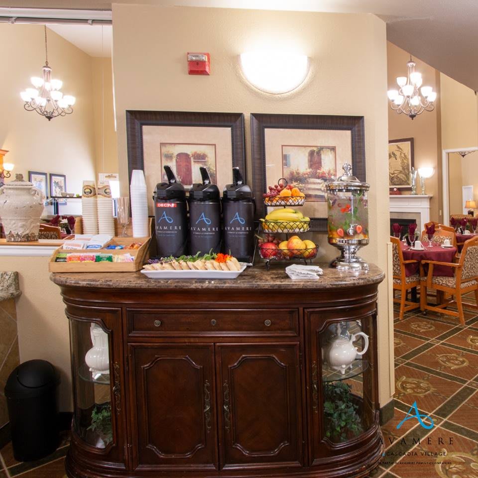 A hotel lobby breakfast area featuring a beverage station with coffee dispensers, fresh fruits, and elegant interior design.