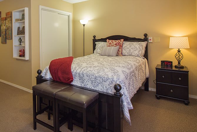 A cozy bedroom with a neatly made bed and soft lighting.