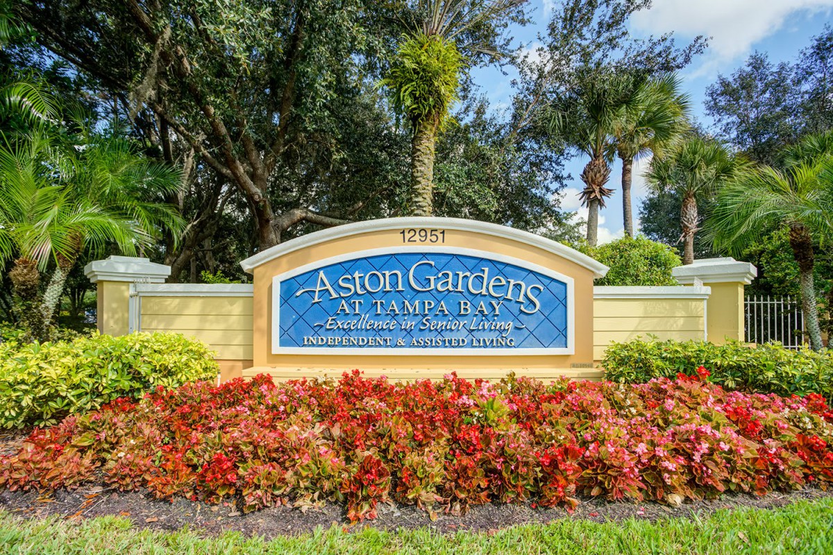 Entrance sign of a retirement community with vibrant landscaping.