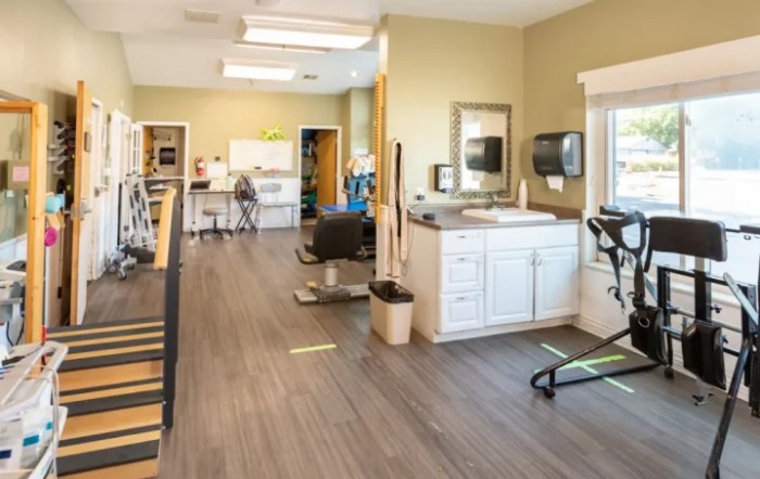 A spacious rehabilitation center equipped with exercise machines and therapy stations.