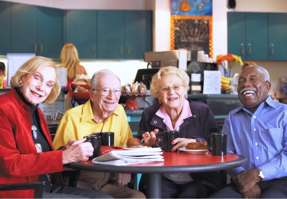 A group of seniors enjoying coffee together in a cafe.