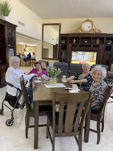 A cheerful gathering of friends enjoying tea and conversation in a senior living community.