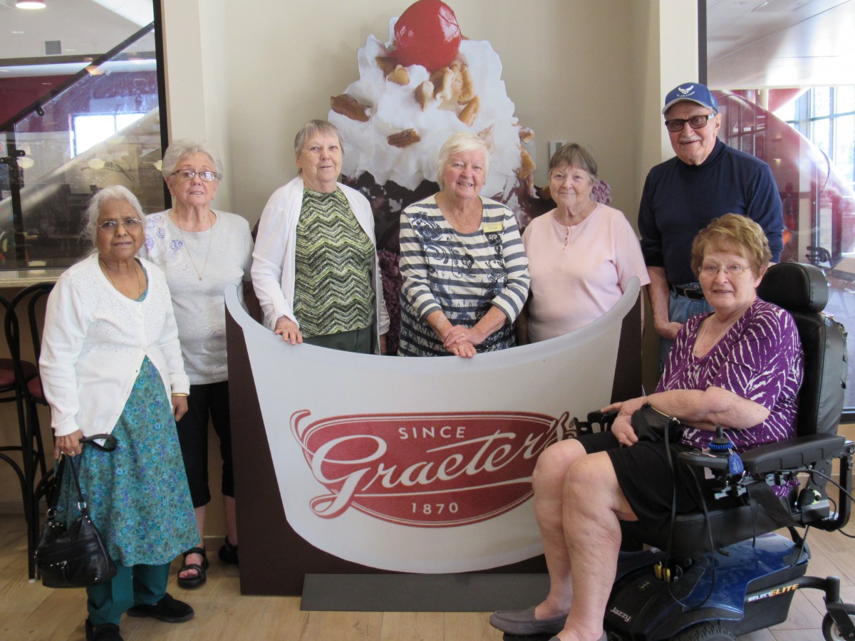 A group of seniors gather for a photo at Graeter's ice cream shop.