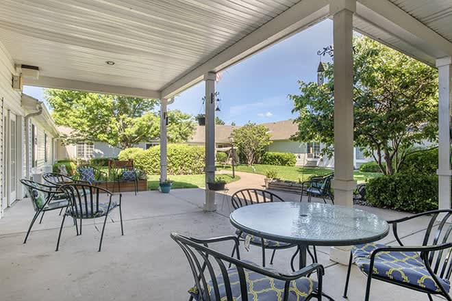 A cozy patio with outdoor seating overlooking a well-maintained garden.