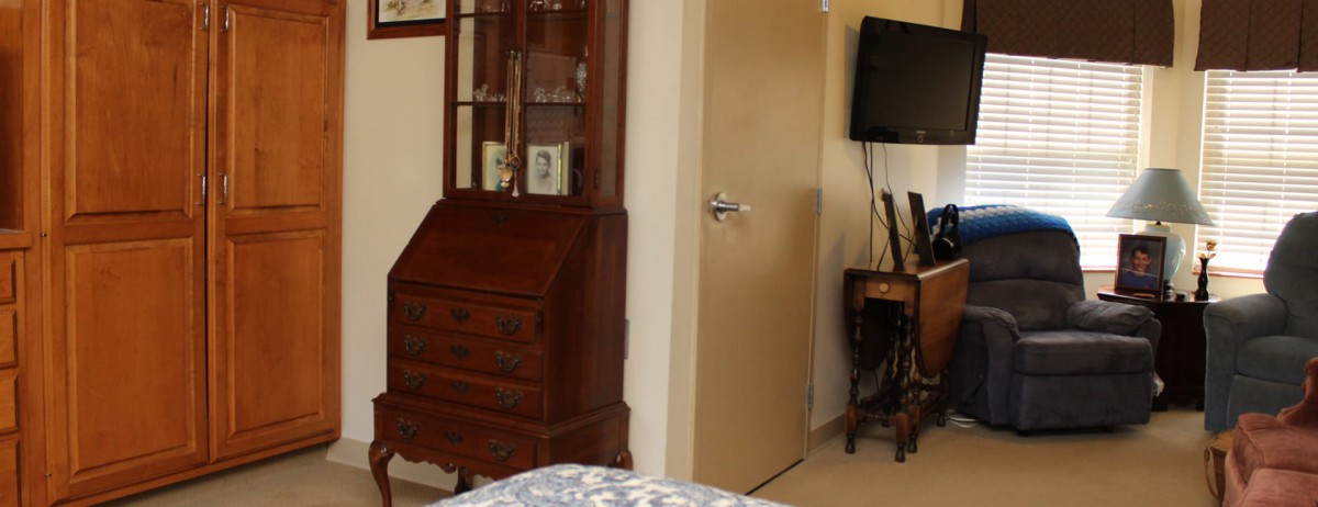 A cozy bedroom interior featuring a wooden cabinet and a mounted television.