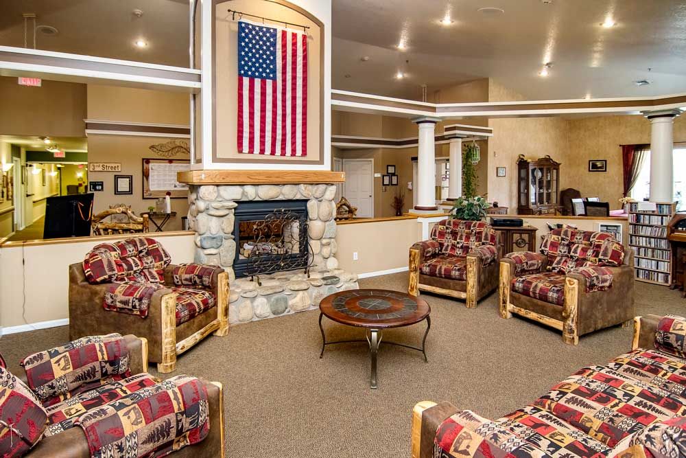 A cozy seating area with a stone fireplace and an American flag hanging above it.