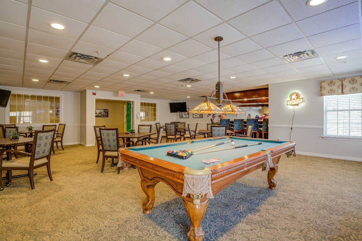 A cozy game room featuring a pool table and bar seating.