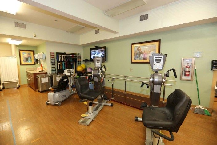A well-equipped gym with exercise machines and a television for entertainment.