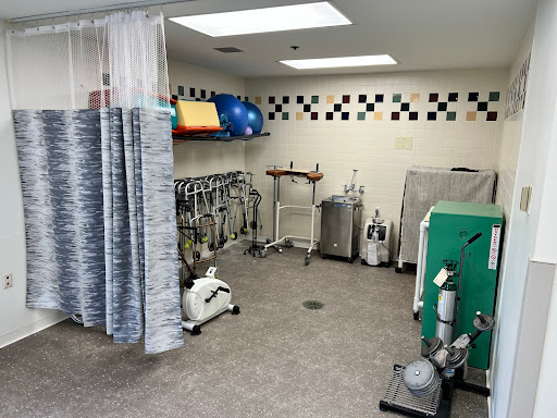 A view of a treatment room equipped for rehabilitation with various medical supplies and equipment.