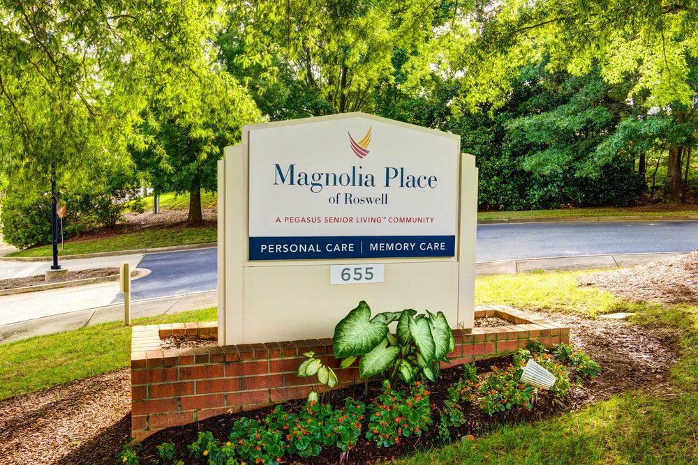 Sign for Magnolia Place, a nursing and rehabilitation center, surrounded by greenery.