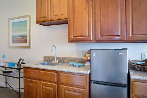 A cozy kitchen featuring wooden cabinets, a functional sink, and a refrigerator.