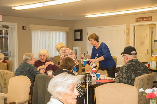 A warm gathering of seniors enjoying food and conversation in a community setting.