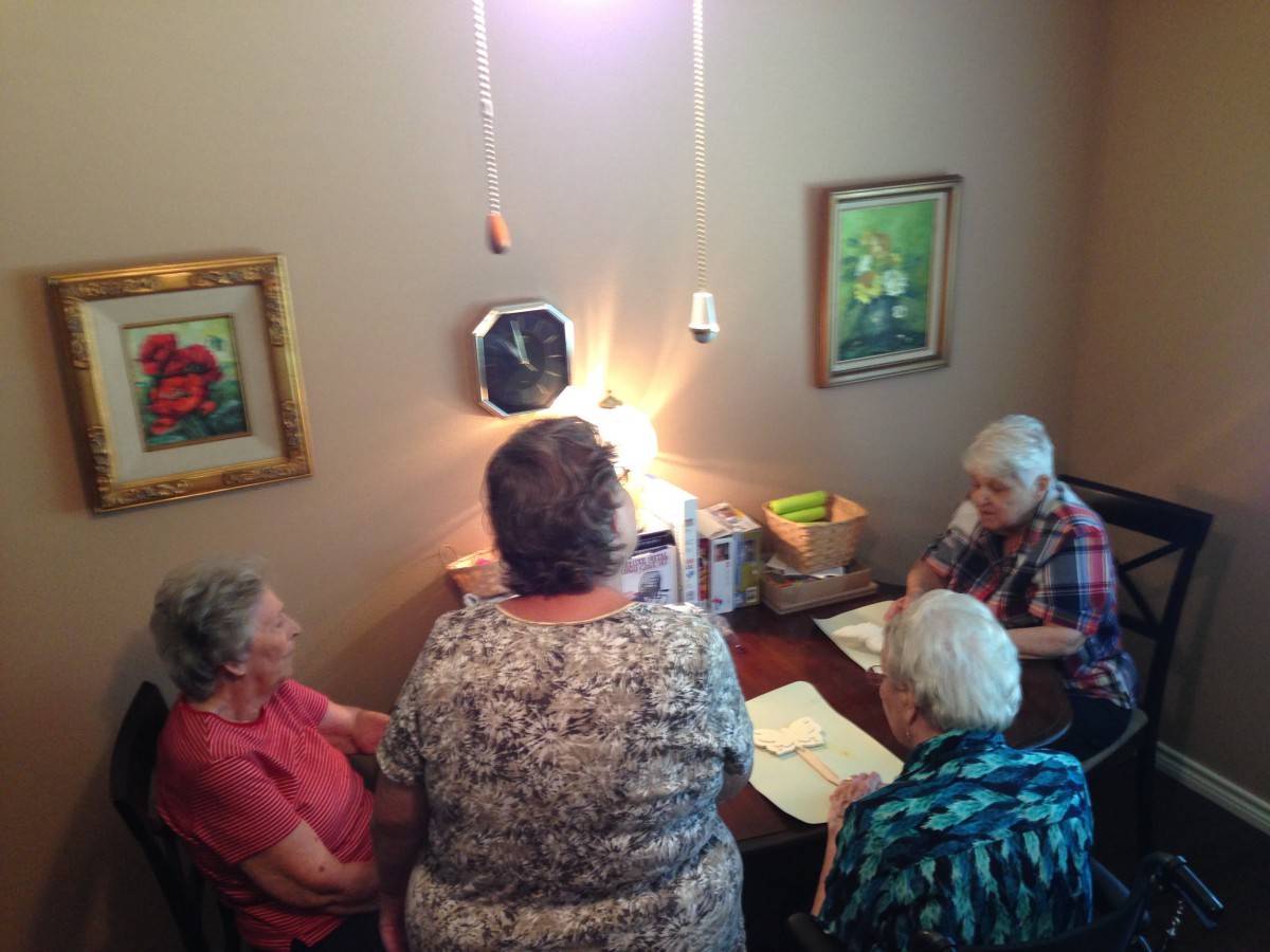 A group of seniors sitting around a table engaged in a discussion or activity.