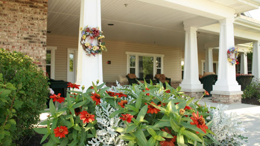 A beautifully landscaped front porch adorned with vibrant flowers and a welcoming wreath.