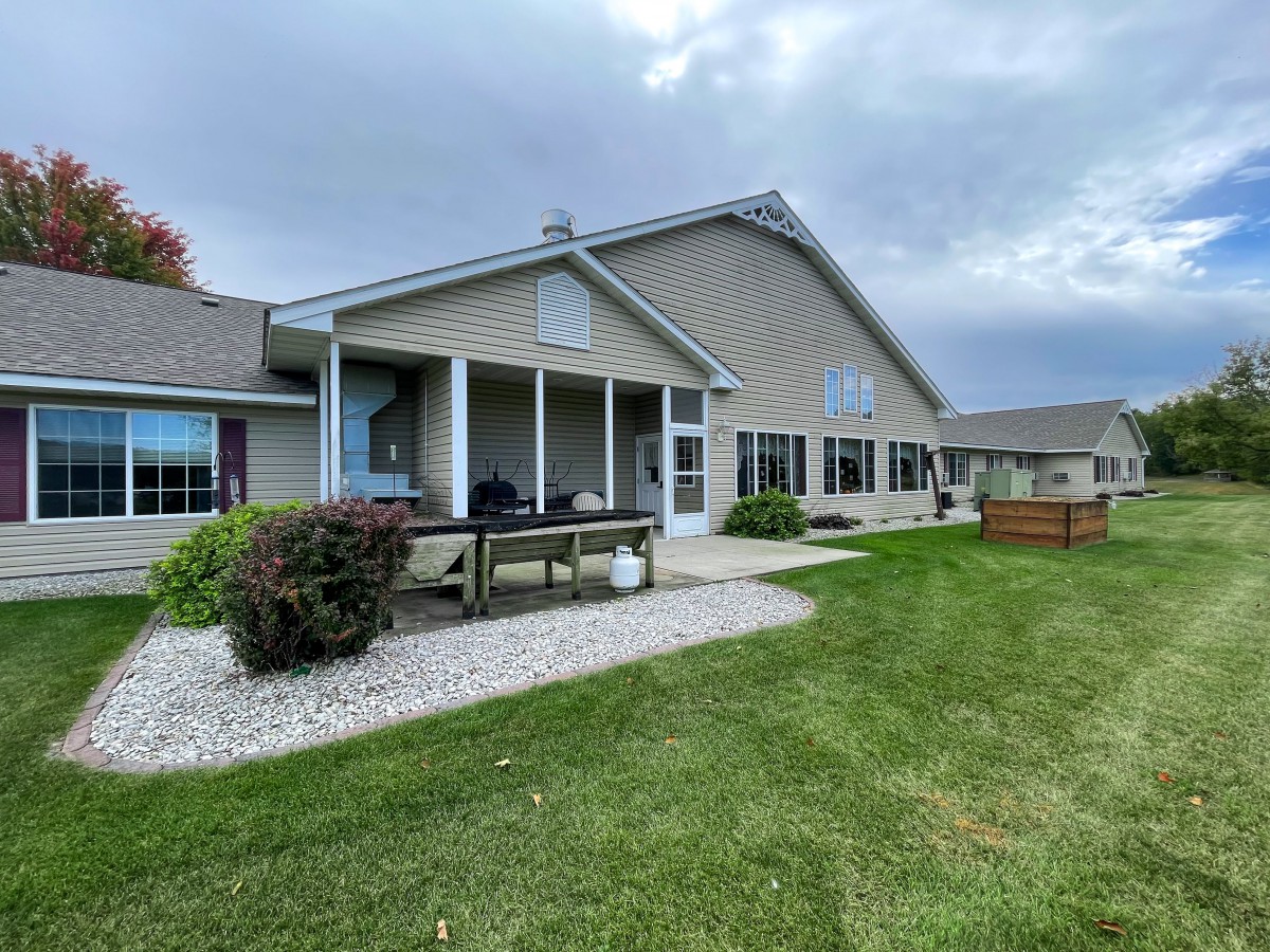 A suburban house with a well-maintained lawn and a cloudy sky in the background.
