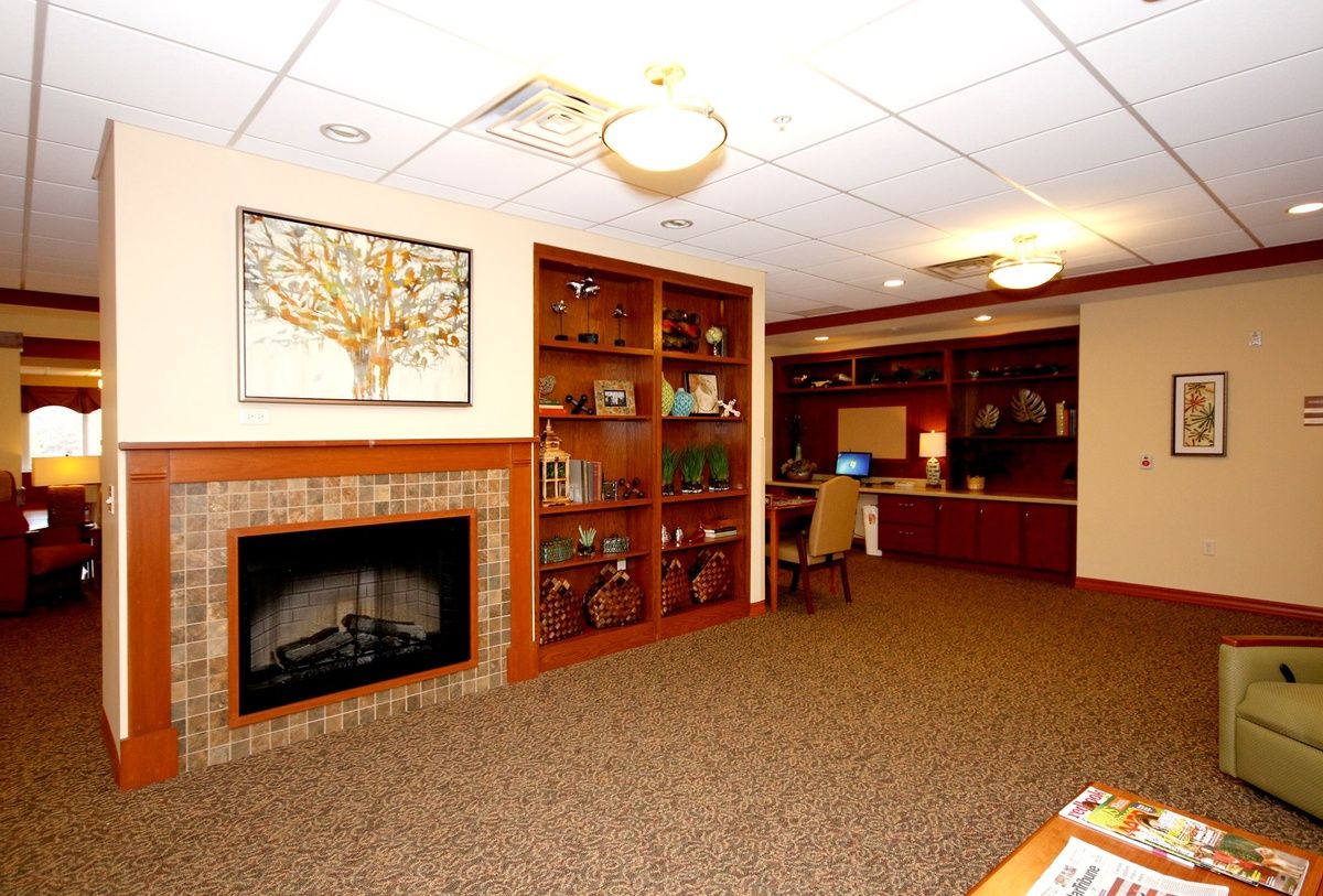 A cozy living space featuring a fireplace, built-in bookshelves, and a reception area.