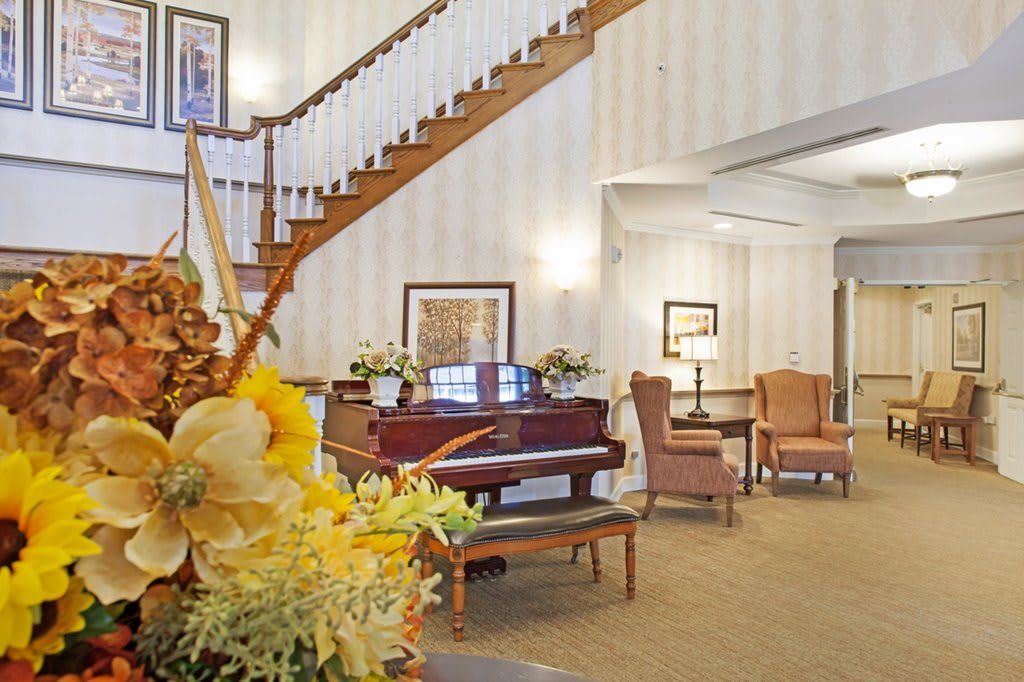 A cozy lobby area featuring a grand piano and elegant staircase.