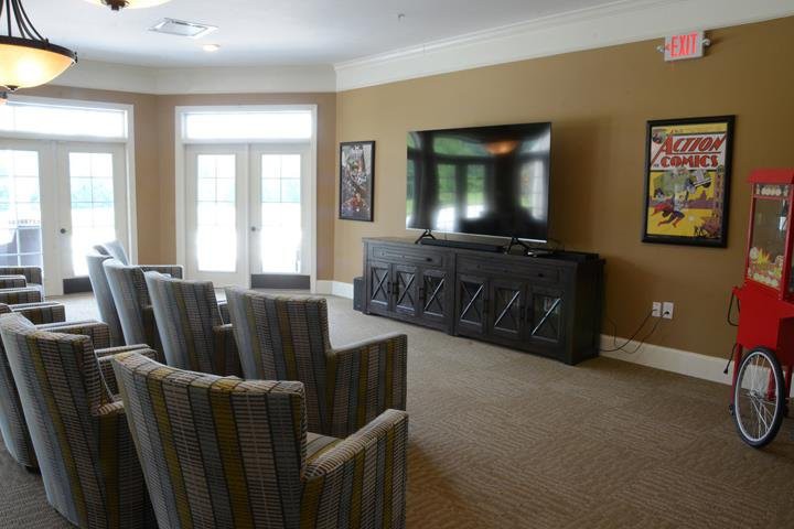 A cozy home theater setup with multiple chairs facing a large TV.
