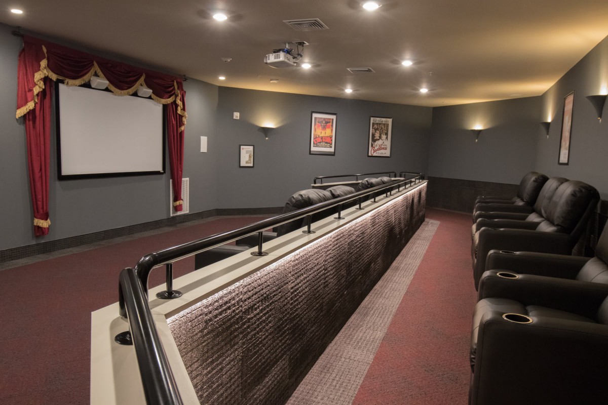 A cozy home theater room with comfortable seating and a large projector screen.
