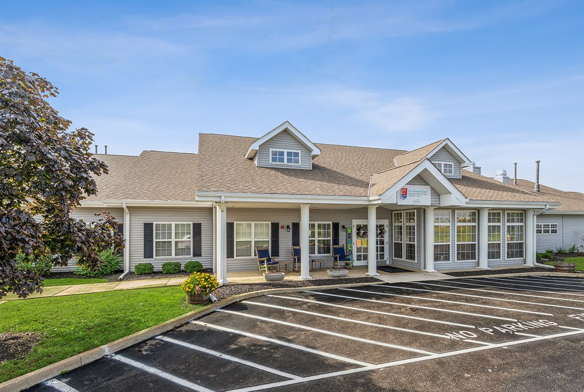 A suburban commercial building with a parking lot on a clear day.