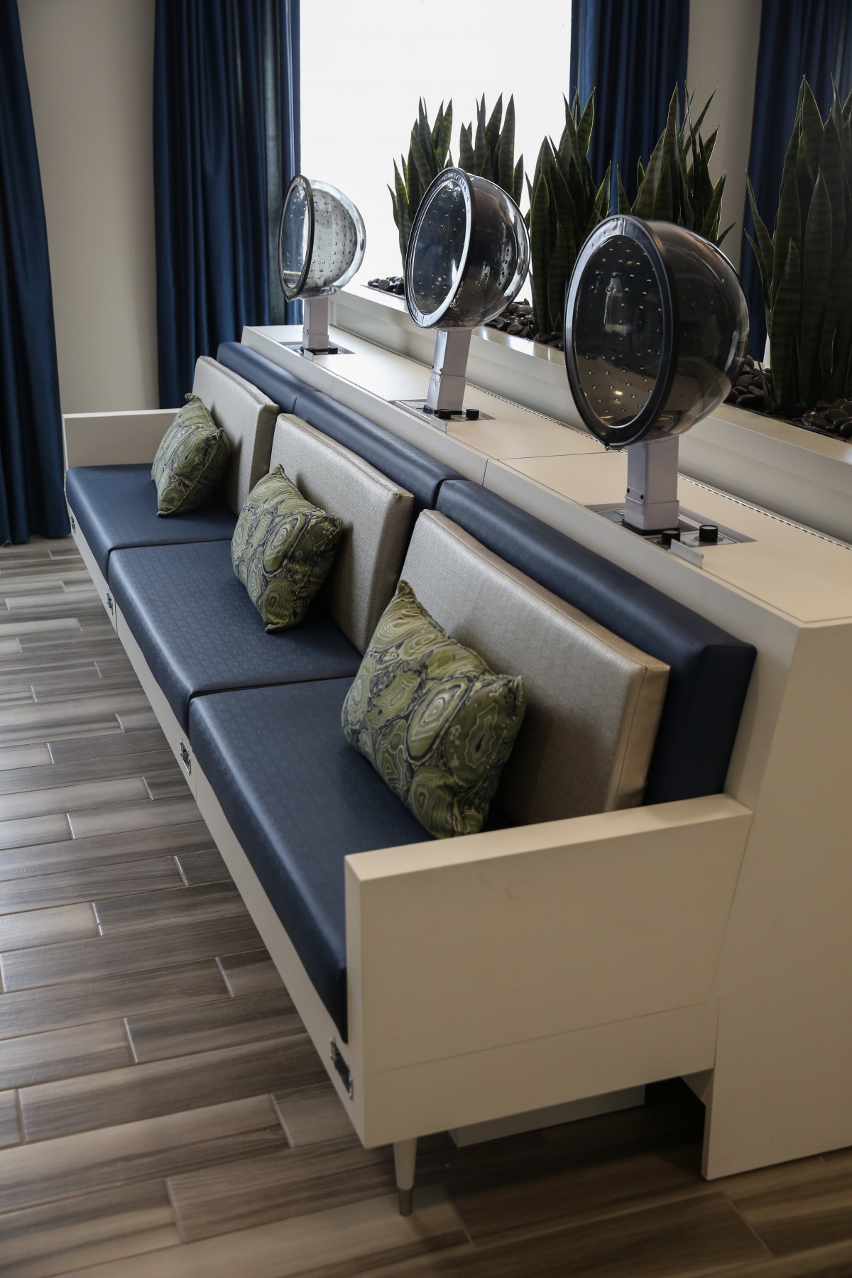 A salon seating area with hair dryers and comfortable cushions.