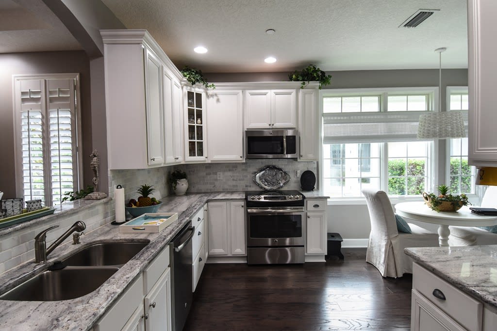 A modern kitchen with white cabinets and stainless steel appliances.
