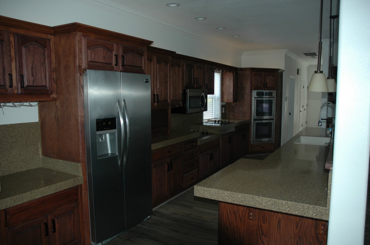 A modern kitchen featuring stainless steel appliances and wooden cabinetry.