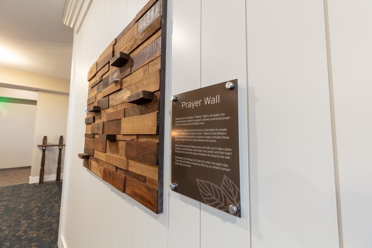 A wooden wall sculpture paired with an informational plaque in a modern interior setting.