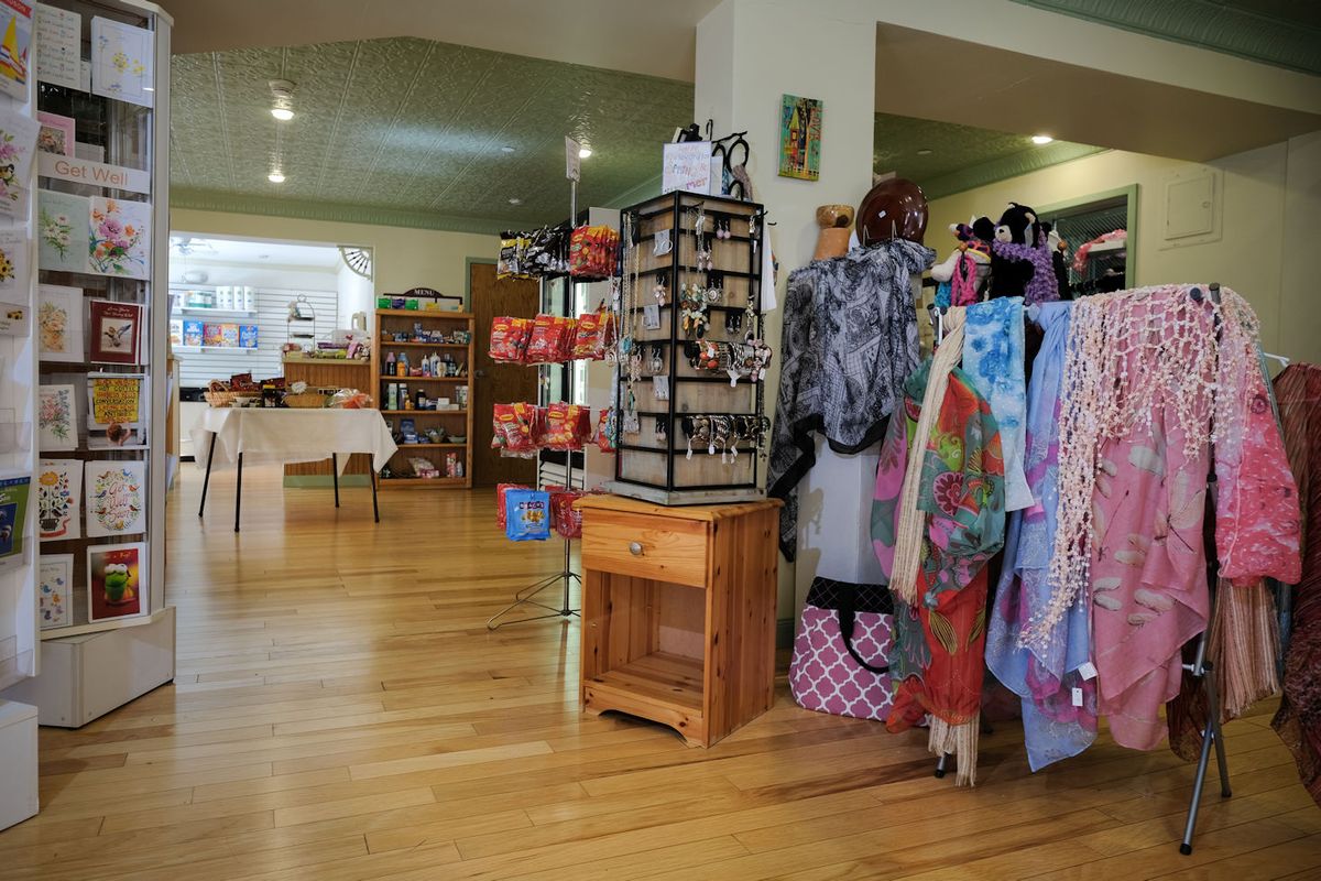 A cozy boutique with colorful clothing and accessories on display.