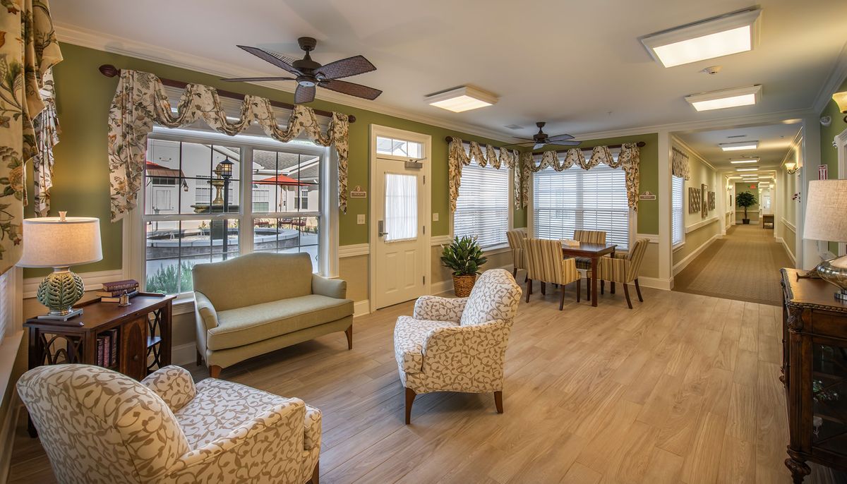 A cozy living area with comfortable seating, a dining table, and large windows that let in natural light.