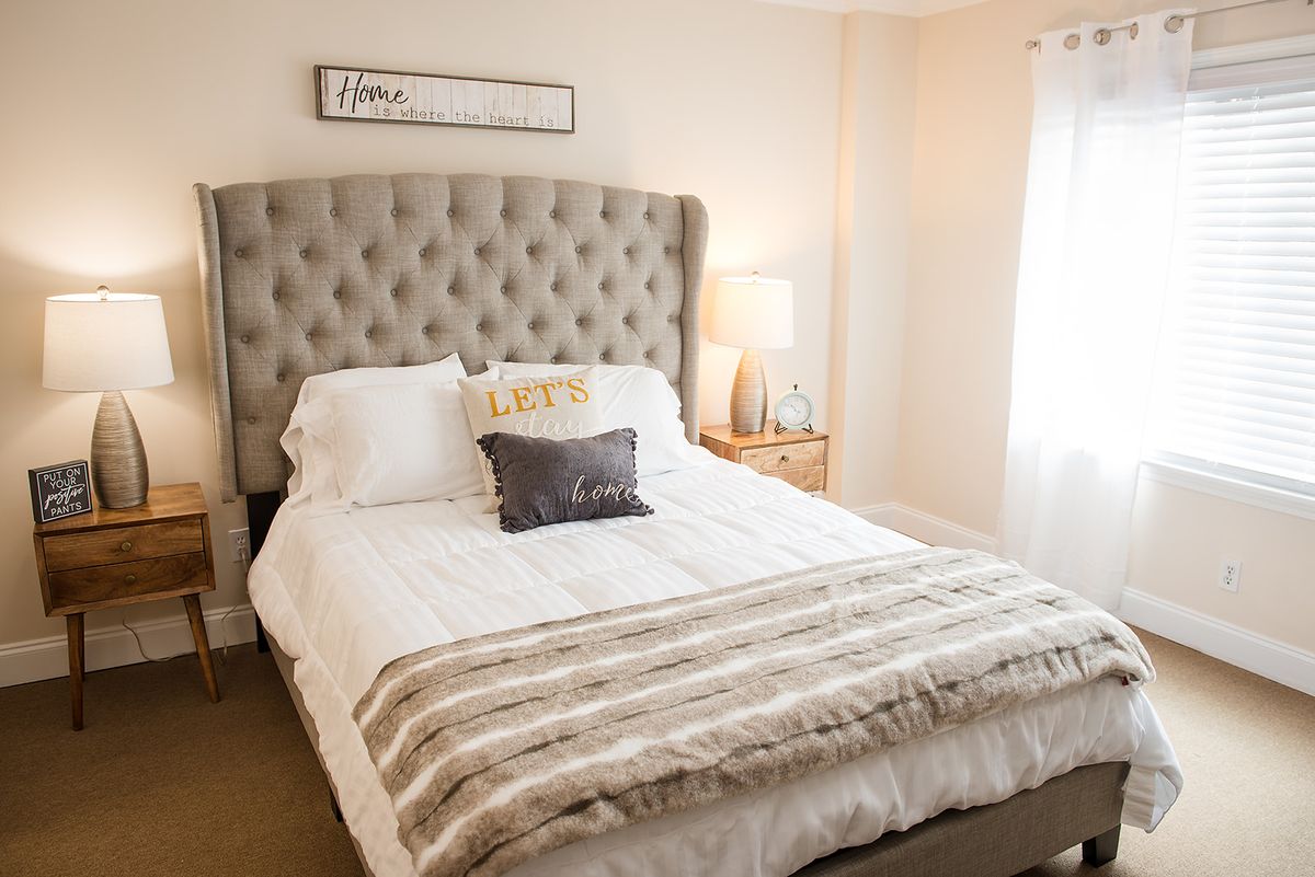 A cozy bedroom with a tufted headboard and stylish decor.