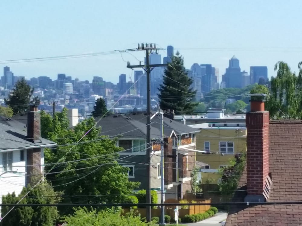 A view of a residential neighborhood with a city skyline in the background.