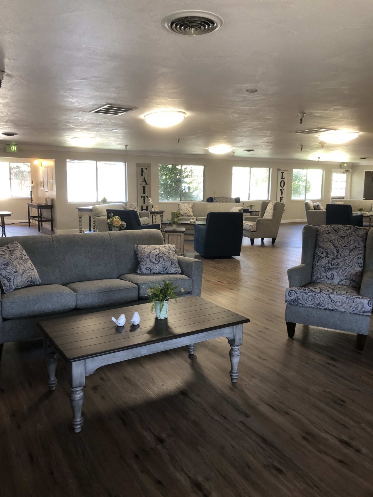 A spacious living room with modern decor, featuring comfortable seating and wooden floors.