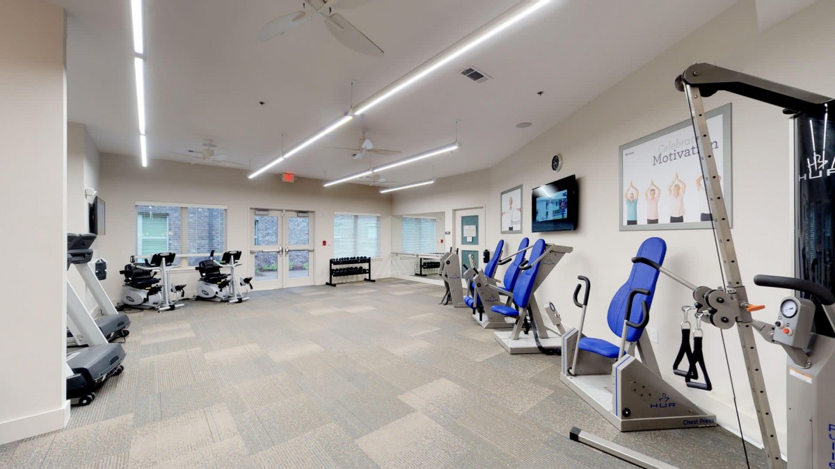 A modern gym with various exercise machines and fitness equipment.