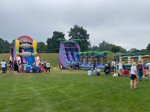 A fun-filled day at the outdoor inflatable playground, featuring colorful bouncy castles and water slides.