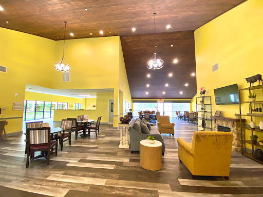 A bright and inviting lobby featuring modern decor with yellow walls and stylish furniture.