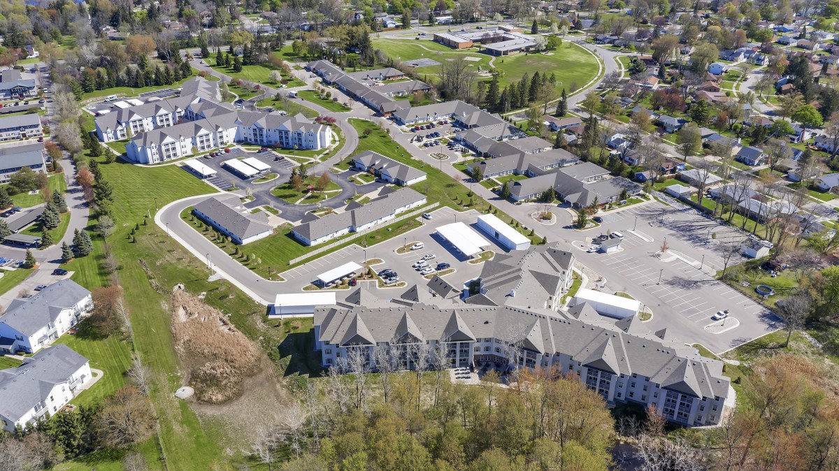 An aerial view of a suburban residential area with multiple buildings and green spaces.