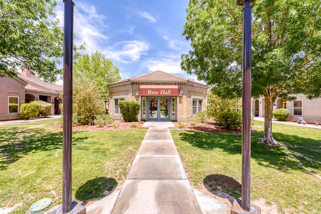 Front view of a healthcare clinic with a clear pathway and surrounding greenery.
